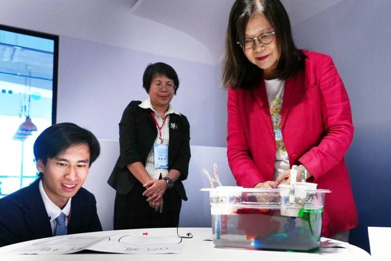 聯合國海洋會議青年代表陳懷璞（左一）與國際海洋素養領袖代表陳麗淑（中）與管主委一同演示海洋科學序列教具