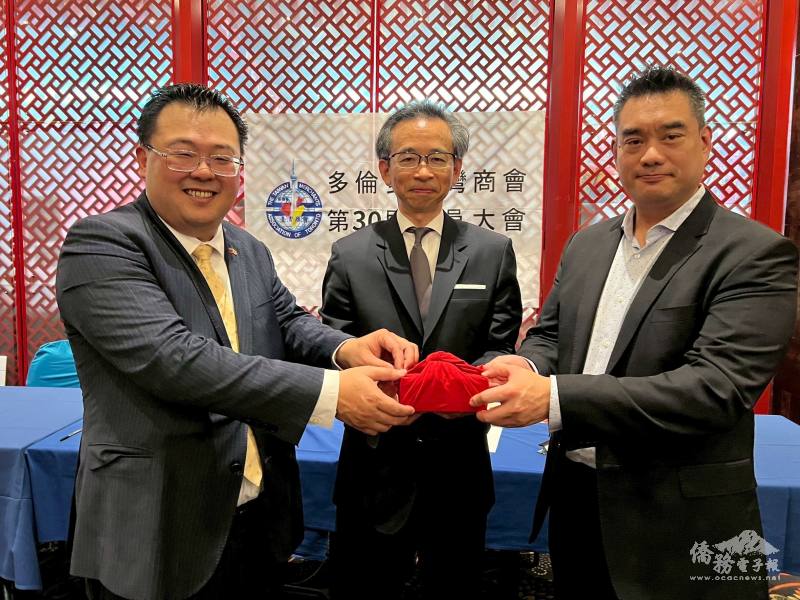 多倫多臺灣商會新會長楊家潤(右)、卸任會長李滄偉印信交接，由駐多倫多辦事處處長梁毅鵬監交