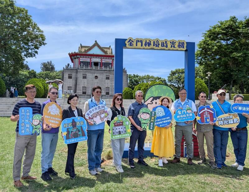 金門縣政府配合交通部觀光署「台灣觀光100亮點，捲動國旅方案」，規劃「金門秘境時光機」活動，推出3條免費軍事體驗遊程，25日活動發布記者會中，金門副縣長李文良（右4）和與會者在莒光樓前「巨大公仔盒」打卡裝置前合影。