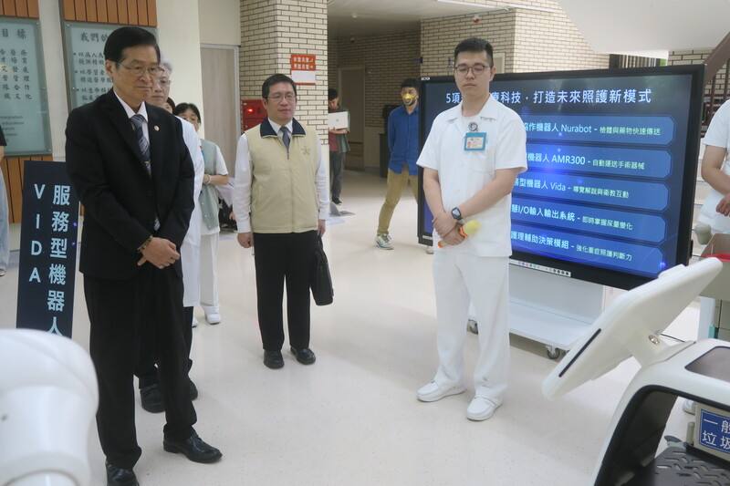 退輔會主委嚴德發（左）24日視導台中榮民總醫院，院方展示多款先進醫療機器人的應用情況