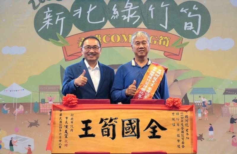 新北市綠竹筍品質有口皆碑，新北市長侯友宜（左）28日頒發匾額給「114年度全國優質安全驗證綠竹筍評鑑」全國有機組筍王賴阿龍（右）。（新北市農業局提供）