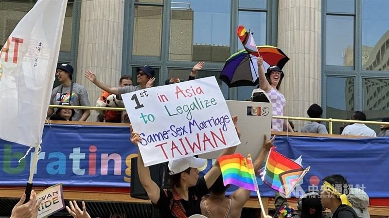 A person holds a sign touting Taiwan as the first country in Asia to legalize same-sex marriage. CNA photo June 29, 2025