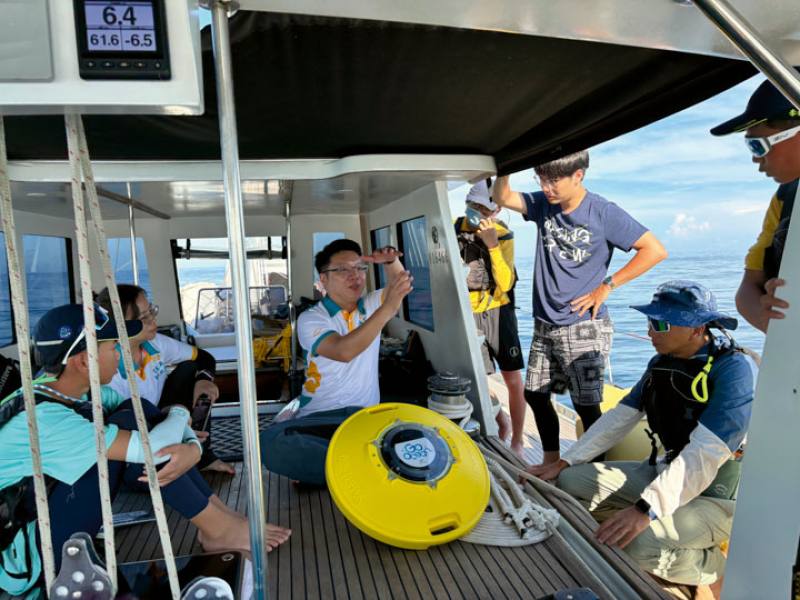 A scientist from the National Academy of Marine Research explains the function of a float buoy to the kids. ​​