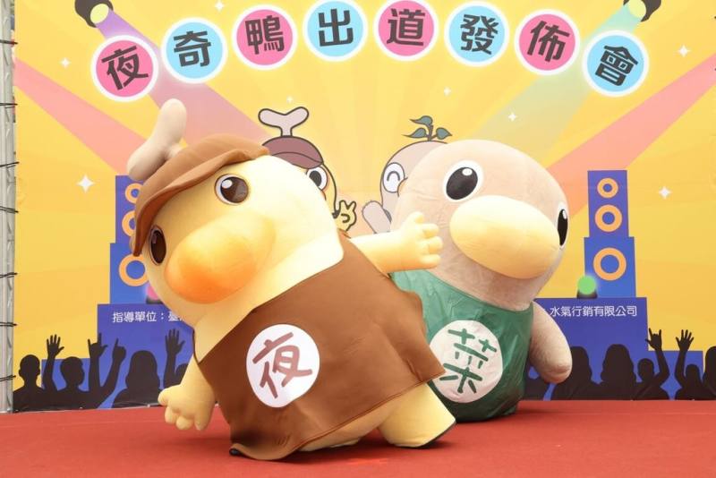 台南夜市吉祥物「夜奇鴨」（前）1日出道，未來將推出多款限定周邊商品，打造「草根系偶像」形象。後為市場吉祥物「菜奇鴨」。（台南市政府提供）