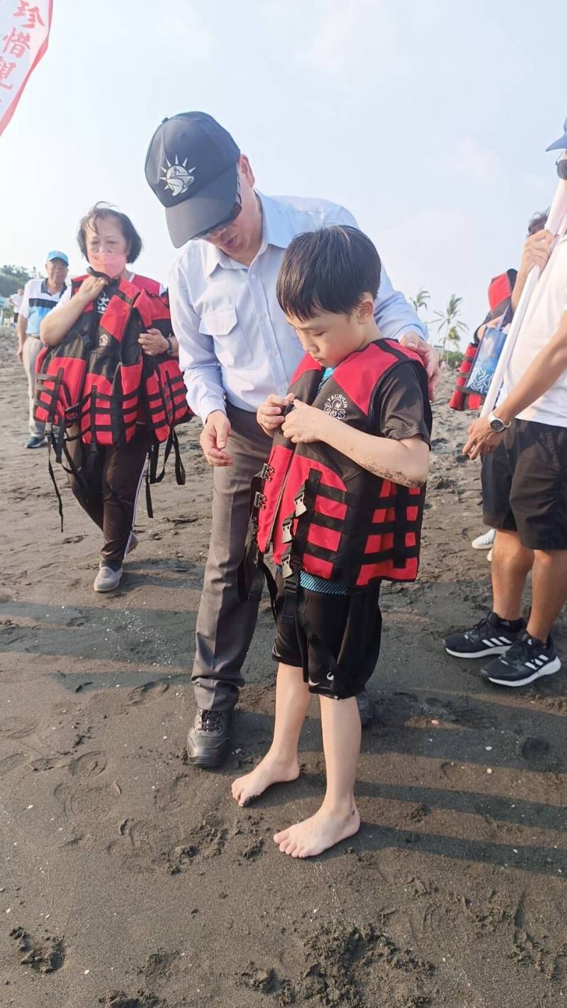 海洋委員會洪挬論處長於旗津宣導海域安全 協助戲水孩童穿著救生衣