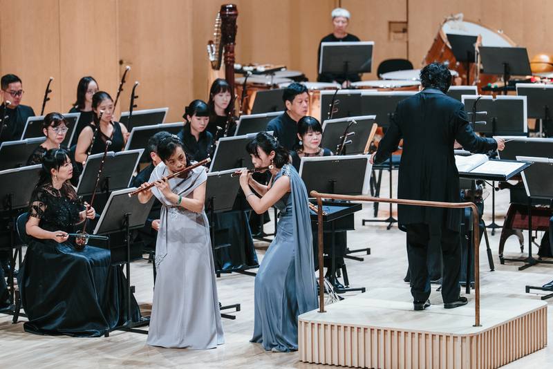 高雄市國樂團受邀芬蘭米凱利市藝術節演出，團員李育慈（前右）跟莊喜淑（前左）共演作曲家陳中申「草螟弄雞公」雙笛協奏曲，全場不時發出會心一笑，印證「音樂無國界」。（高市國提供，張簡承恩攝）