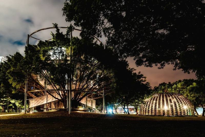 高雄駁二藝術特區裝置藝術「大樹宇宙－愛河森林慢板」（左）為藝術家顏名宏2022年時的創作，在COVID-19疫情期間，他以一座與自然共生的藝術作品作為回應民眾對綠意、陽光、空氣的渴望。（駁二藝術特區提供）