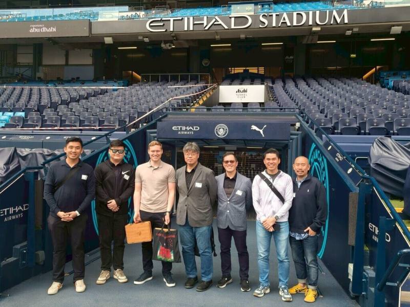 高雄市政府受邀至英國參加2025年體育館商業高峰會，並入圍「贊助、銷售與行銷獎」，副市長李懷仁（中）率團參加大會，並實地參訪英國在地指標性場館。圖為伊蒂哈德球場。（高雄市文化局提供）