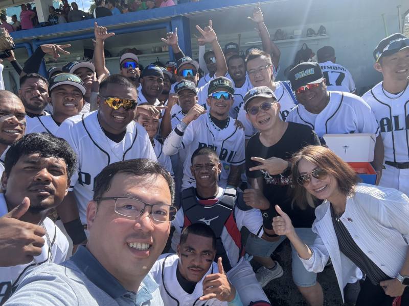2日帛琉棒球隊首戰勝場後，張廖萬堅次長(中右3)和鄭世忠署長(前排左3)與帛琉棒球隊合照