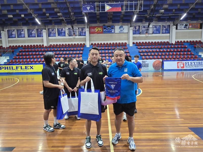 中正學院藍龍籃球隊教練陳忠華（右）贈送紀念品予臺灣中信高中男子籃球隊領隊陳柏年（左）