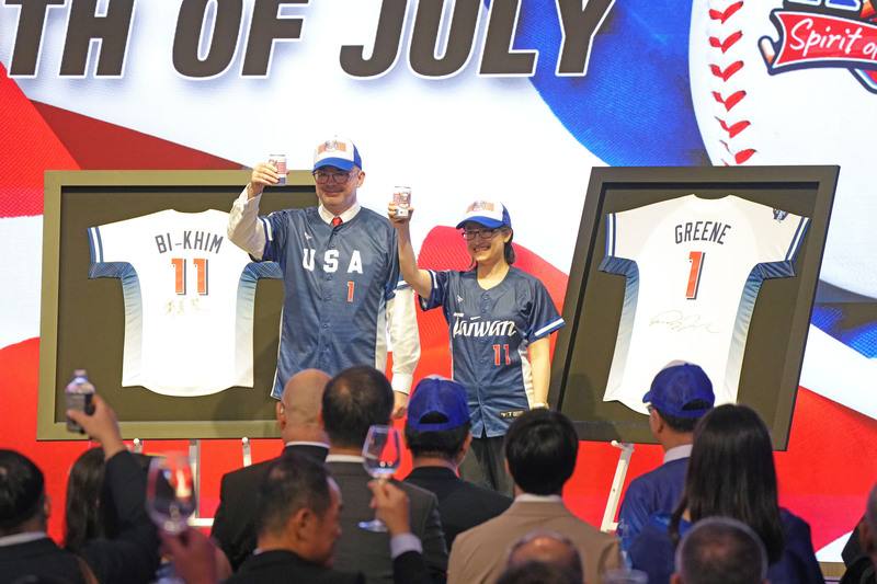 美國在台協會（AIT）2日舉辦美國獨立紀念日249週年慶祝酒會，今年活動以「棒球」為主題，AIT處長谷立言（左）及副總統蕭美琴（右）穿上球衣敬酒