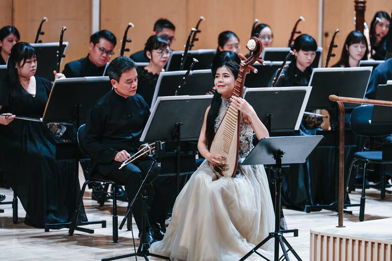 芬蘭米凱利藝術節2日由高雄市國樂團舉行壓軸音樂會，圖為樂團彈撥聲部長趙怡然（前）與樂團合奏，技巧精湛。（高市交提供，張簡承恩攝）