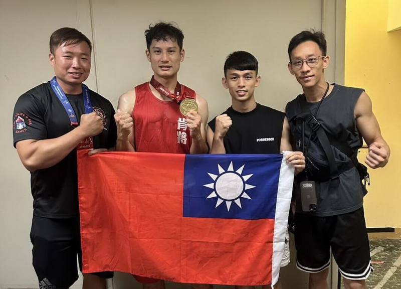 2025世界警察消防運動會在美國阿拉巴馬州舉行，新北市消防局特搜大隊慈福分隊員陳鵬畯（左2）在拳擊項目勇奪金牌，賽後與教練等人一起持國旗合影。（新北市消防局提供）