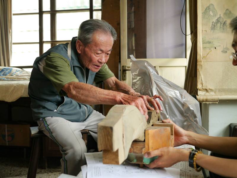 重要文化資產保存技術「大木作技術」保存者許漢珍於7月5日辭世，長期致力於傳統大木作技術，以及廟宇空間木作結網技術傳承，圖為其講解斗拱搭接方式。（成功大學建築系徐明福教授研究室提供）