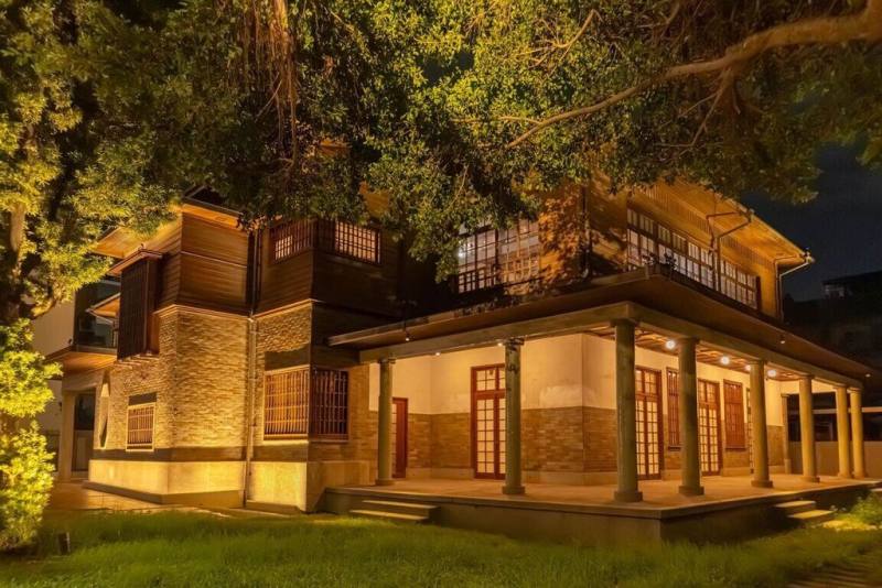 台南400城市光環境改造計畫首波成果亮相，其中市定古蹟愛國婦人會館以暖黃光線透出窗格，搭配庭院樹影與步道燈具，營造靜謐溫潤的夜間氛圍。（台南市政府提供）