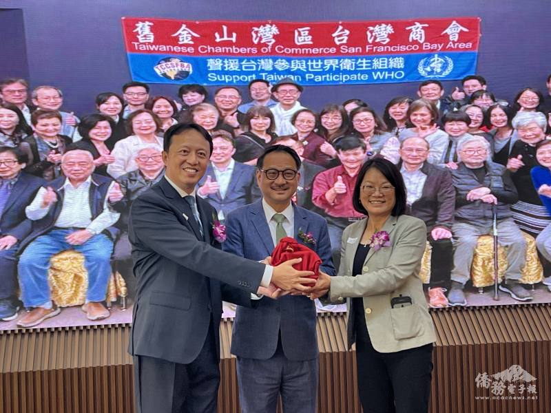 商會會長交接。左起:滿任會長周威宇、僑委會副委員長阮昭雄及新任會長何淑貞