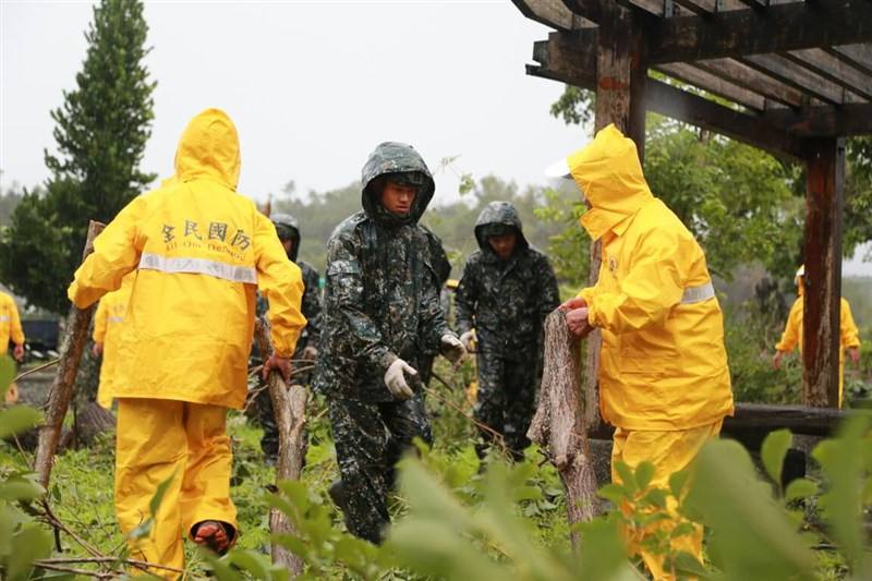 Reservists and soldiers help with post-typhoon cleanup work in the rain in Chiayi Thursday.