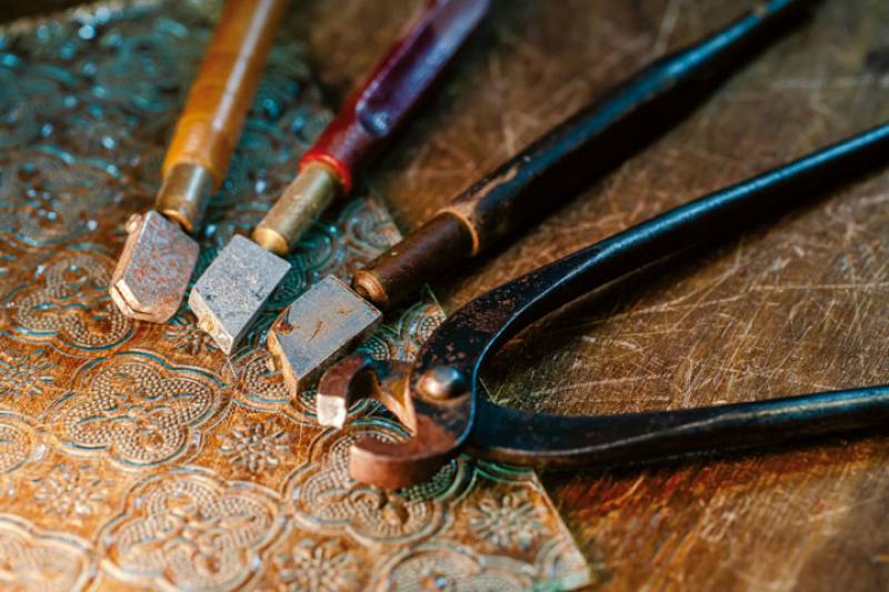 劉勁廷展示切割玻璃的工具，早期的壓花玻璃厚度僅2～3mm，要用手工小心切割