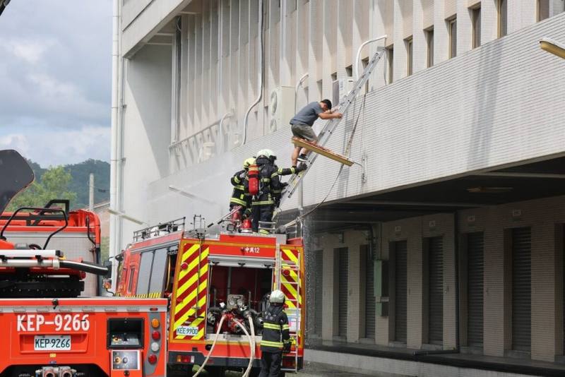 南投縣15日下午進行2025城鎮韌性（防空）演習，於中華電信南投營運處模擬飛彈來襲成災的搶救疏散，消防局出動水箱車及雲梯車等，救出受困及受傷人員。（南投縣政府提供）