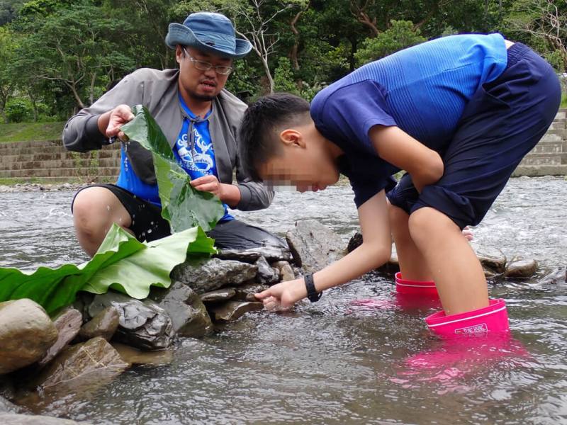 林業及自然保育署屏東分署雙流自然教育中心2024年「魚米之鄉－楓港溪的漁撈記憶」活動，由原民講師Kuljing（谷栗英）（左）示範傳統改水道捕魚法
