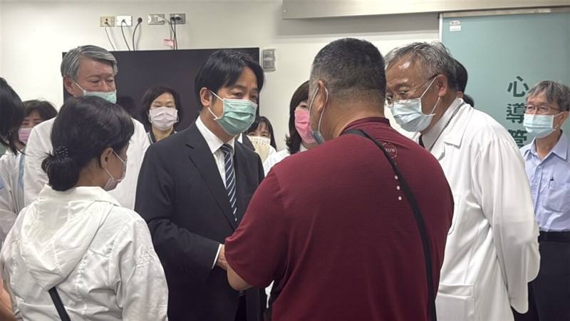 President Lai Ching-te (in suit) visits the family of Lee Yuan-han, a Taipower employee who was electrocuted while repairing power poles in Chiayi County following Typhoon Danas, at a hospital in Tainan on Wednesday