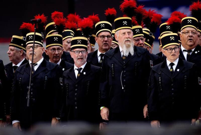 由曾在魯爾礦區作業的礦工所組成的合唱團，穿著德國礦工儀典服飾獻唱「礦工之歌」。帽子上繡有象徵德國採礦業的錘與鑿