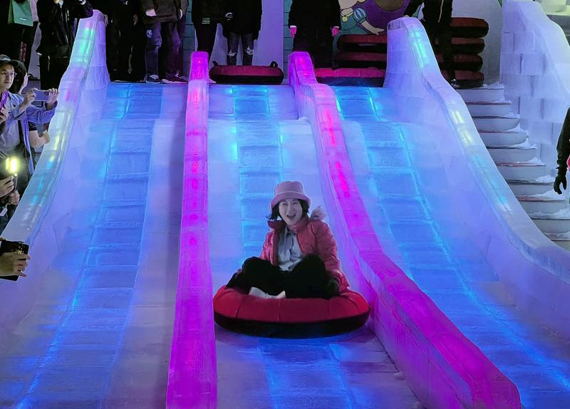 2025屏東夏日狂歡祭19日起正式登場，今年特別打造「冰宮城堡」，內部溫度保持在攝氏零下10度，屏東縣長周春米（前）18日出席開幕式並親自體驗13公尺長的冰雕溜滑梯