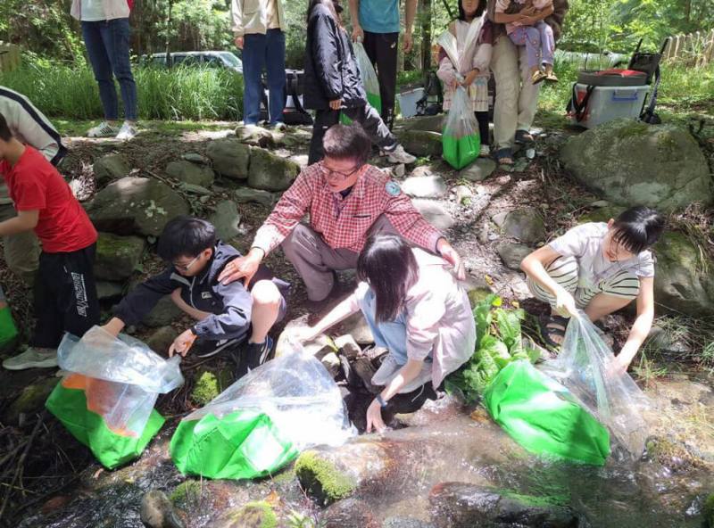台灣櫻花鉤吻鮭生態中心舉辦各項推廣國寶魚保育工作，吸引親子共同參與，是雪霸國家公園別具特色的秒殺活動。圖為小小巡守員放流體驗。（雪霸國家公園管理處提供）