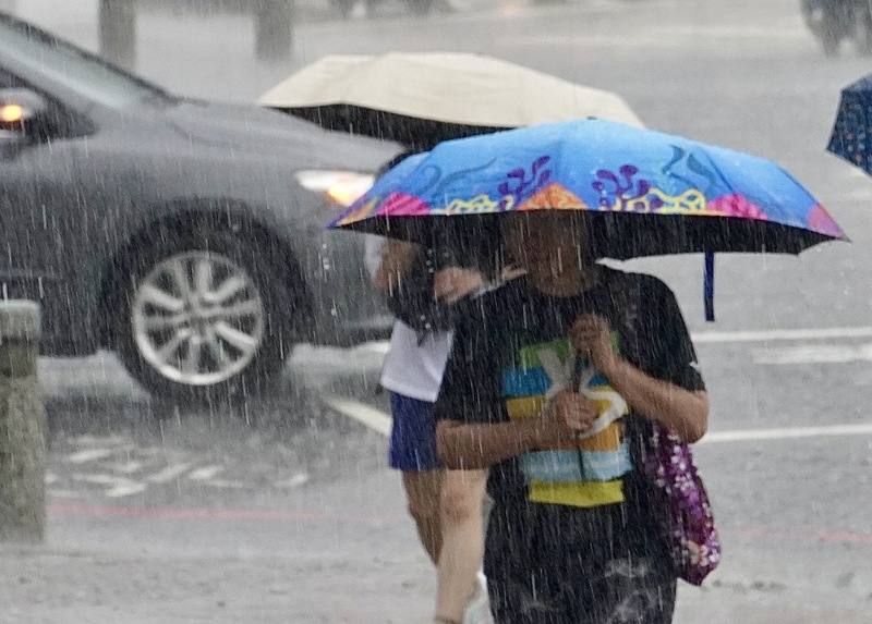 受颱風薇帕外圍環流影響，易有短延時強降雨，北北基及南投以南等11縣市須留意局部地區有大雨及豪雨。圖為高雄市前金區民眾18日傍晚撐傘遮擋雨勢