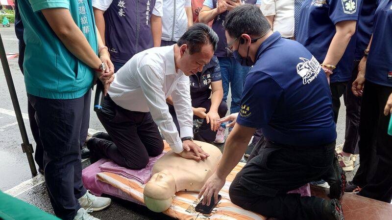 嘉義縣長翁章梁（中）19日到國立民雄高級農工職業學校出席複合式健康篩檢活動，並在消防局宣導攤位前學習心肺復甦術