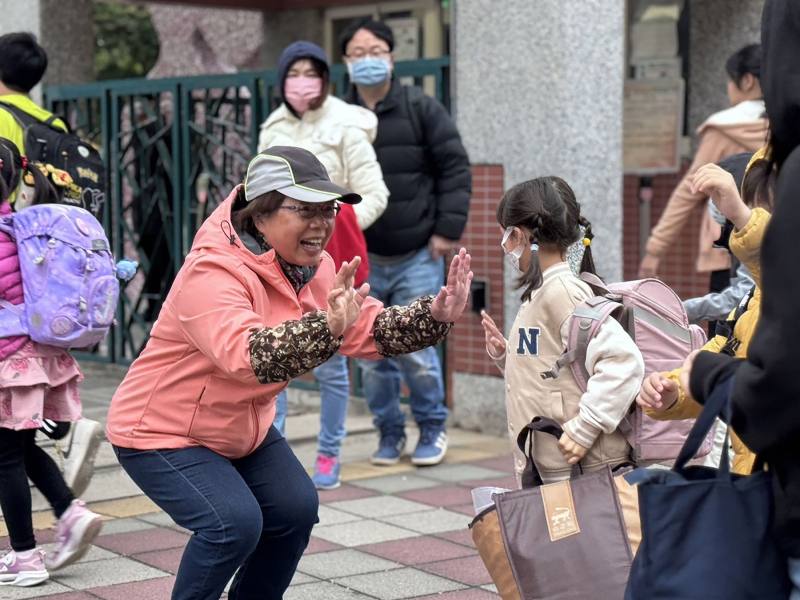 每天早晨，葉瑞珠校長（中）站在校門口迎接學生，張開雙手給孩子最熱情的問候