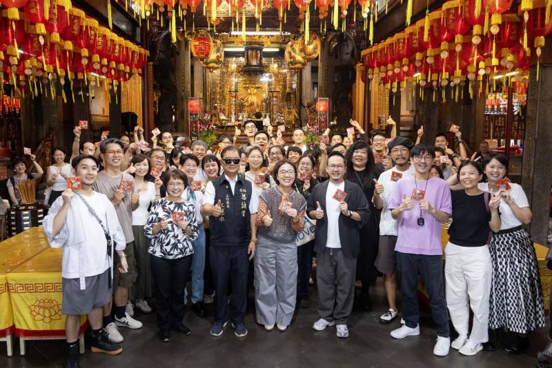 「We TAIWAN」參與團隊手持慈諴宮主任委員江運永代表廟方致贈的「小神衣」，期盼活動一切順利、收穫滿載。