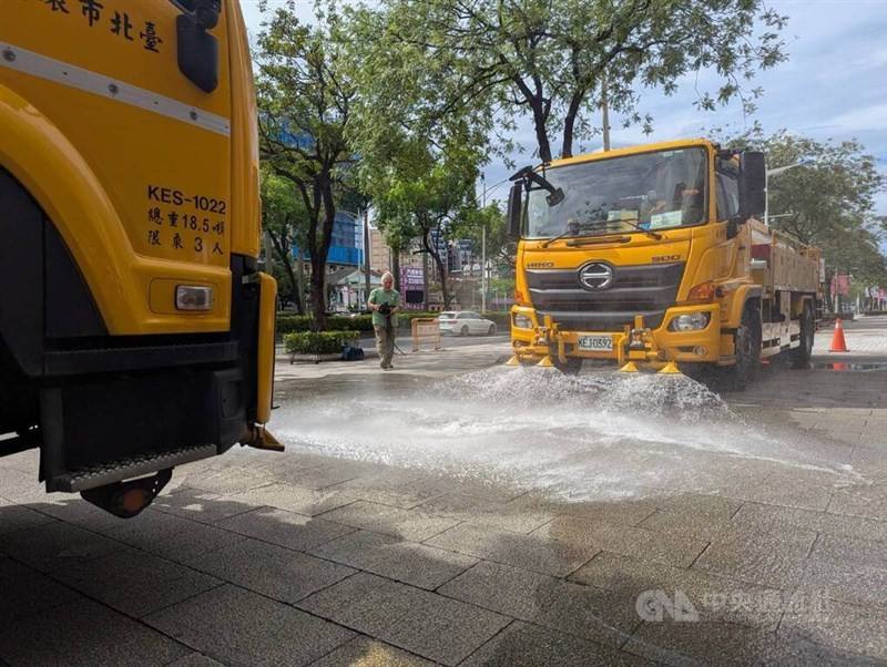 Two water trucks spray a street in Taipei to cool the area during Tuesday's drill. CNA photo July 22, 2025