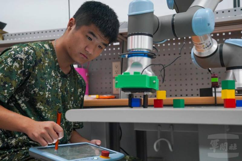 國防大學理工學院「國防科技實作研習營」23日進行第二天課程，學員專注實施機械手臂操作