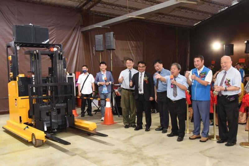 苗栗縣長鍾東錦（前右2）25日出席恆智重機公司在苗栗總部舉行的「AI無人堆高機測試場地」開幕儀式，聽取廠方說明無人堆高機配備精密儀器和功能。（苗栗縣政府提供）