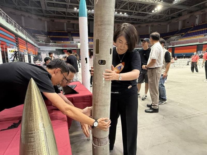 屏東縣政府26日舉辦台灣盃火箭競賽決賽直播活動，縣長周春米（前中）參訪各科普教育創意攤位，並與師生一同動手體驗火箭原理等