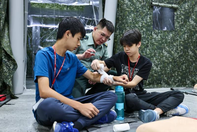 「醫學暨戰傷救護研習營」學員進行「創傷包紮」實作課程。（青年日報提供）