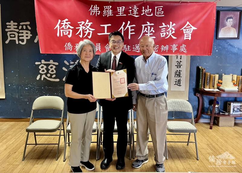 周啟宇處長(中)代表僑委會頒贈僑務諮詢委員聘書予許照惠博士(左)