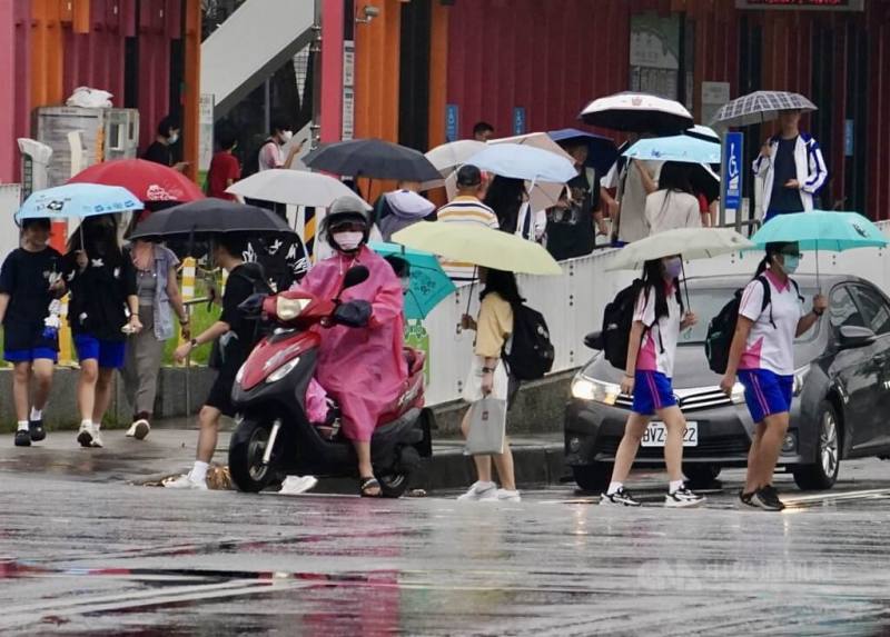 圖為高雄市前鎮區學生撐傘過馬路。（中央社檔案照片）