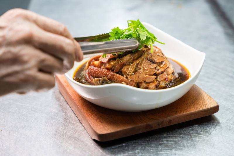 新北市客家文化園區歡慶20週年，2日以「新客覺醒」為主題辦活動，以「新客餐桌」為活動亮點，由5家不同領域的餐飲品牌跨界合作推桌宴，呈現酸香濃厚的客家風味，風味餐點包括梅干扣肉與福菜肉片湯等。（新北市府客家事務局提供）