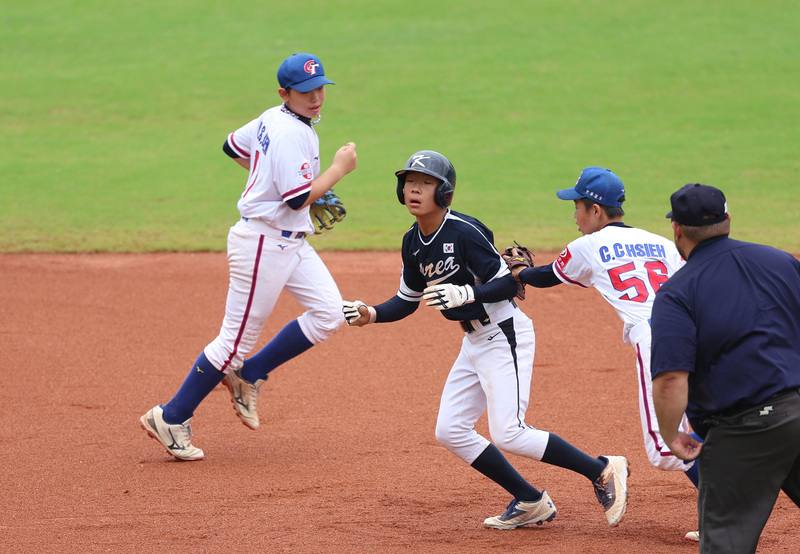 U12世界盃棒球賽季軍戰，台灣與韓國交手在台南亞太國際棒球訓練中心舉行，4局上謝承濬（右2）與隊友將韓國跑者夾殺出局