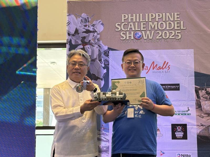 第2屆菲律賓比例模型大賽3日閉幕，駐菲副代表楊登仕（左）頒獎給台灣模型愛好者黃康家。