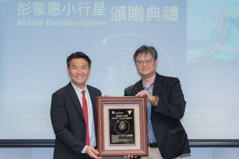中央大學將編號603380小行星命名為「彭蒙惠（Doris Brougham）」，由中央大學主任祕書李宇翔（右）致贈彭蒙惠小行星銘版，向已故的空中英語教室創辦人彭蒙惠致敬，由空中英語教室執行長謝光哲（左）代表接受。（中央大學提供）