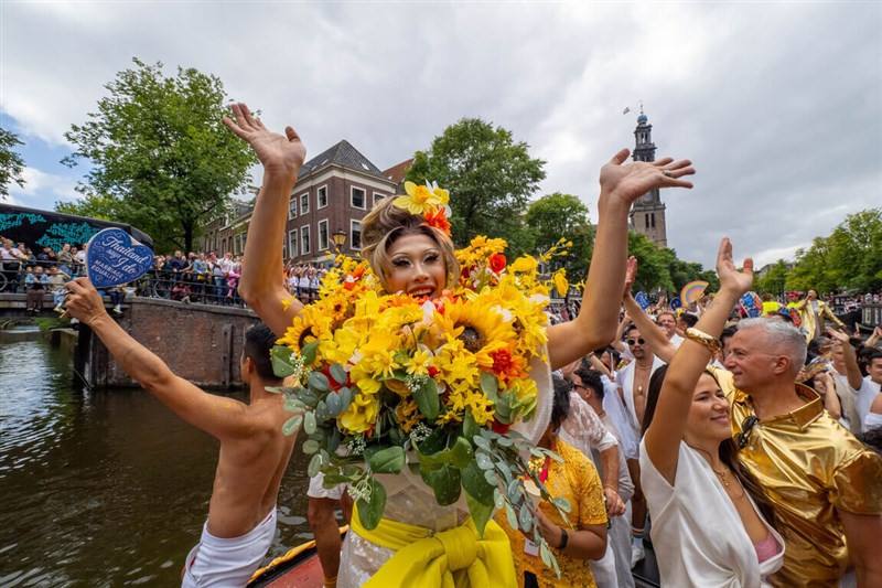 Taiwanese drag queen Nymphia Wind (in bouquet costume) waves to onlookers at the Amsterdam Canal Pride on Saturday. Photo courtesy of Tao.co_studio Aug. 4, 2025