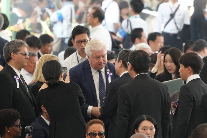 2025年8月6日是「原爆日」80週年紀念日。駐日代表李逸洋6日代表台灣首度出席廣島市和平紀念儀式，與美國駐日大使葛拉斯（中，白髮者）開場前在場內握手寒暄。