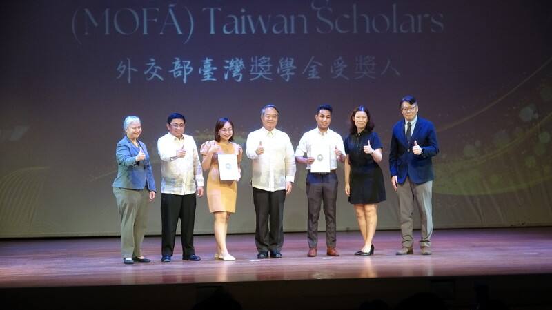 駐菲律賓代表處7日頒發台灣獎學金，今年首次納入外交部台灣獎學金，深化台菲教育交流與人才培育合作。圖為駐菲代表周民淦（中）、代表處官員、菲律賓政府官員以及兩名受獎生合影。