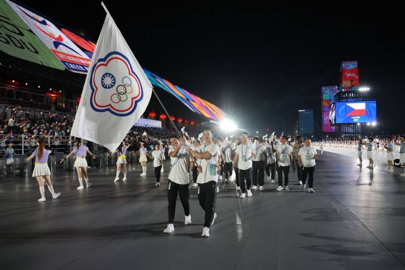 2025成都世界運動會7日晚間盛大舉行開幕式，台灣代表團由武術好手孫家閎（前右）、蹼泳女將黃渼茜（前左）共同擔任掌旗官，兩人進場時難掩開心神情。（中華奧會提供）