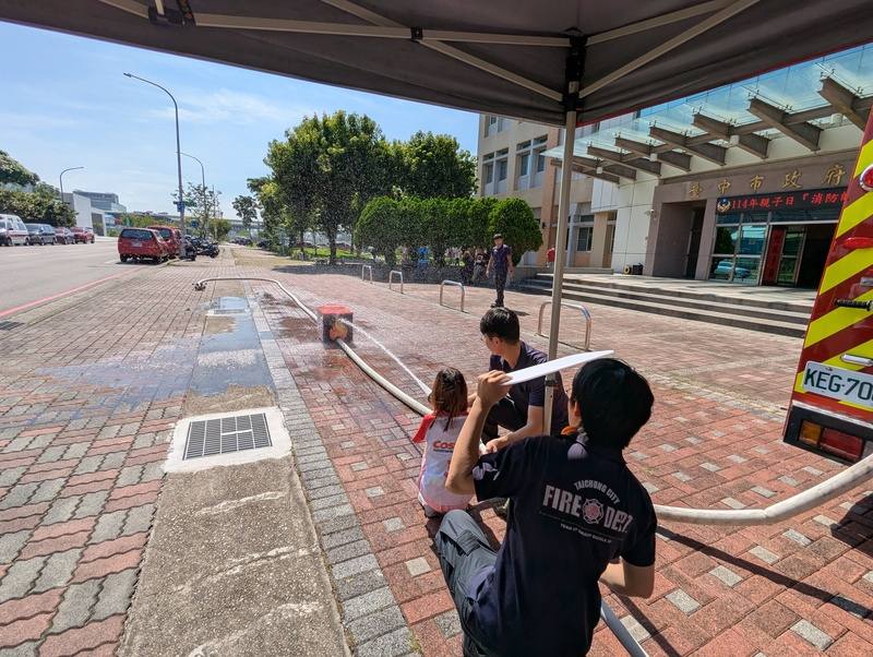 台中市消防局8日舉辦「消防帥老爸」親子主題活動，邀請消防員與孩子一同參與，透過射水滅火關卡，讓孩童體驗父親的工作日常