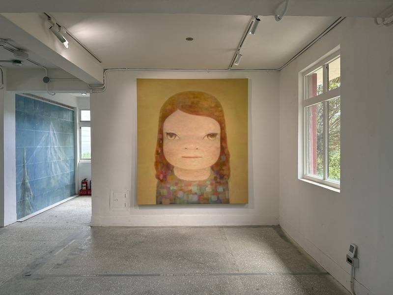 日本當代藝術家奈良美智「跟著朦朧潮濕的一天去旅行」巡迴特展正在新北瑞芳「台電金水基地」展出。「朦朧潮濕的一天」這幅作品是奈良美智感謝台灣在日本311大地震和COVID-19疫情初期，向日本先後捐贈物資和口罩所創作的巨型畫作