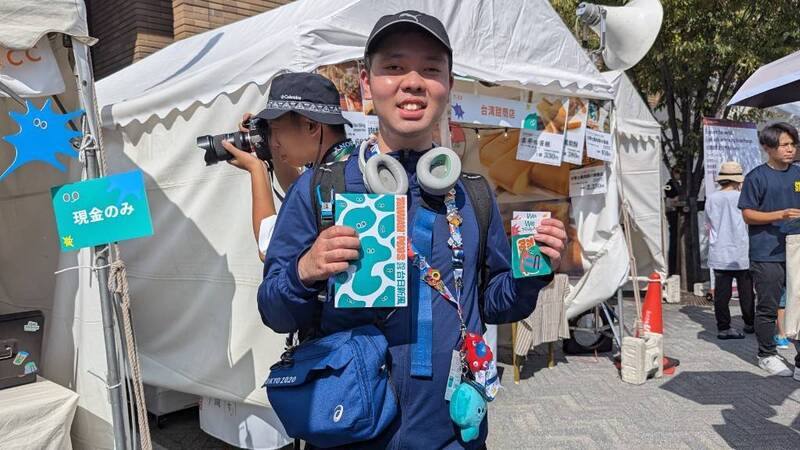 A Japanese visitor, shows off his "a-We" merchandize in Osaka, Japan, on Saturday. CNA photo Aug. 9, 2025